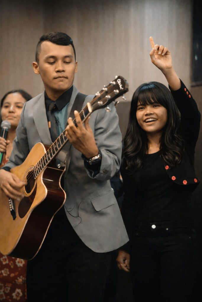 Worship moment with guitar music during church service in Medan showing spiritual connection and joyful praise